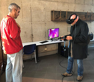 Image of Nobel Laureate Prof. Kip Thorne exploring the the VR app, assisted by Dr. Christopher Russell.
